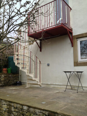 A bespoke metal balcony with spiral staircase steps down (by Derbyshire Dales Engineering)