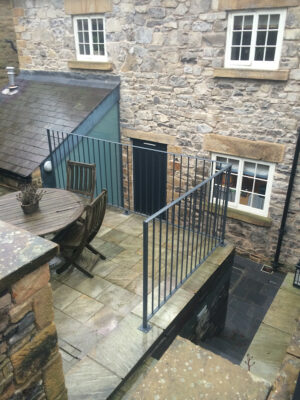 A simple small corner railing to a raised patio eating area (by Derbyshire Dales Engineering)