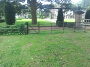 A custom small black metal gate in beautiful grounds