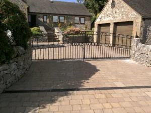 A curved pair of black metal drive gates