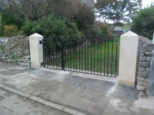 An ornate, custom-designed black metal gate (with railing to the side)