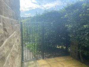 A gate and railing to the side of a property