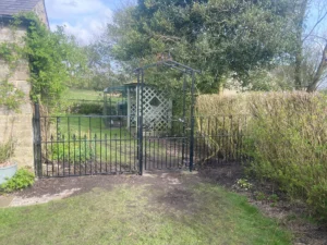 Rotten wooden fence and struction replaced with metal railings and gate (the finished job closer)