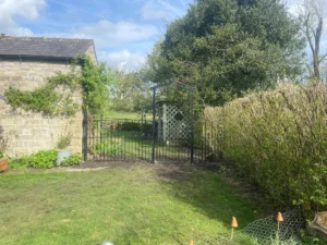 Rotten wooden fence and struction replaced with metal railings and gate (the finished job from a distance)